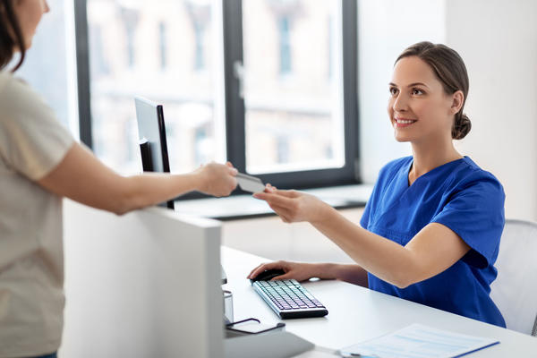 Nursing handing papers to patient