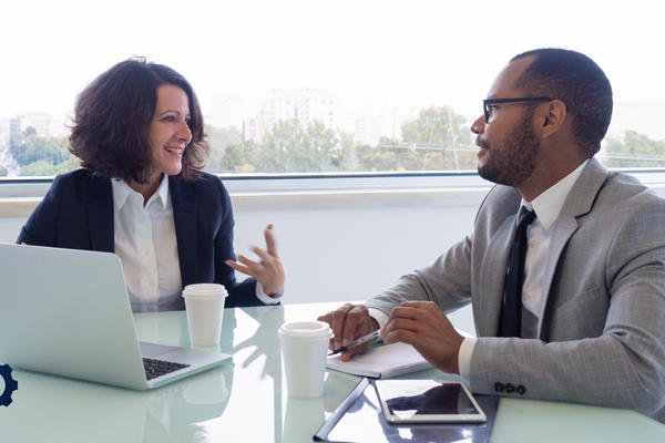 Two people talking at a desk