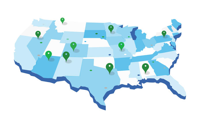 Map of the United States drawn in shades of light blue with green pins spread across the states